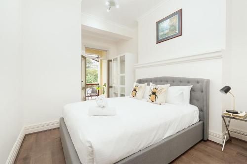 a white bedroom with a large bed and a window at STUNNING SYDNEY HOME 10 in Sydney