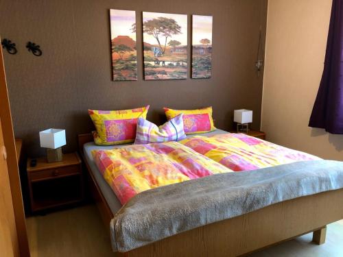 a bedroom with a bed with two pictures on the wall at Hotel garni Zum Adenauer Forst in Wimbach