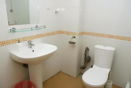a white bathroom with a sink and a toilet at Hotel 7 in Skopje