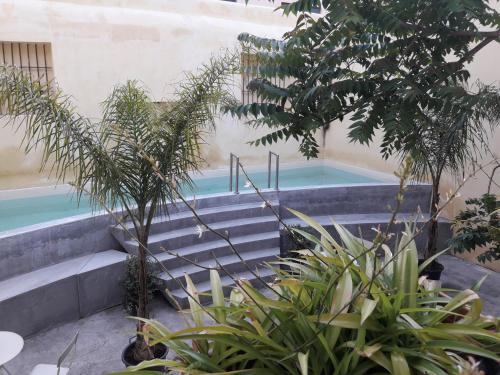 a swimming pool with stairs next to a building at B&B Porta Carolina in Palermo
