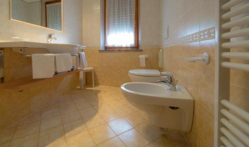 a bathroom with a toilet and a sink at Hotel Beau Sejour Pré-Saint-Didier in Pré-Saint-Didier