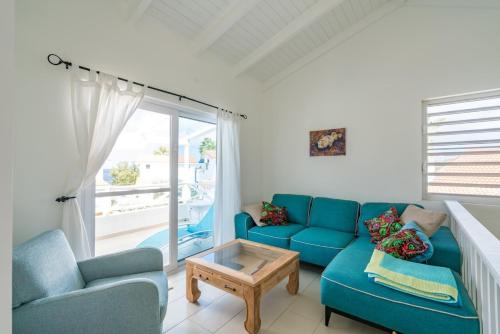 a living room with a blue couch and a table at Marazul Dive Resort in Sabana Westpunt