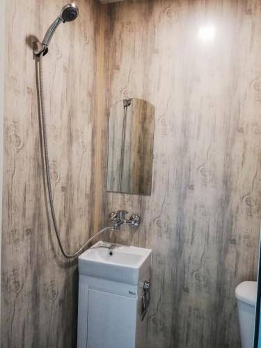 a bathroom with a toilet and a sink and a mirror at Hotel Romantika in Varna City