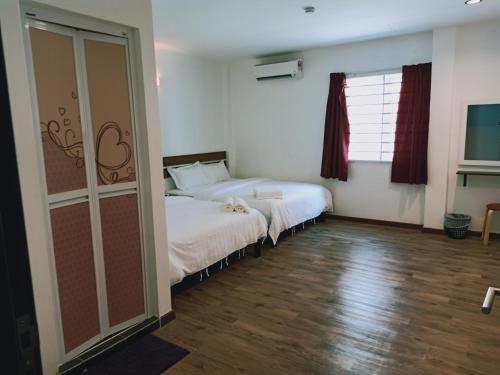 a bedroom with a white bed and a window at Cozy Riverside Hotel in Melaka