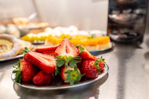 a plate of strawberries on top of a counter at Hotel Villa EDEN in Jihlava