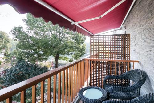 a balcony with two chairs on a wooden deck at Floral Hotel · Yingxi Riverside Deqing in Deqing