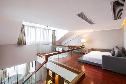 a bedroom with a bed and a glass staircase at Floral Hotel · Yingxi Riverside Deqing in Deqing