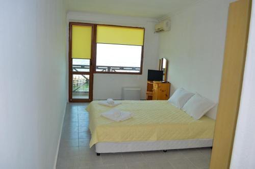 a bedroom with a bed and a window at Hotel Romantika in Varna City