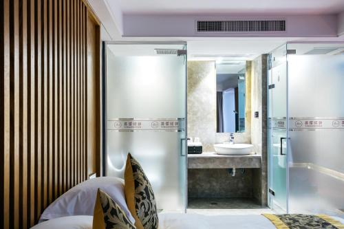 a bathroom with a shower and a sink at Floral Hotel · Yingxi Riverside Deqing in Deqing