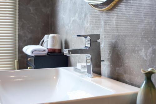 a sink with a faucet in a bathroom at Floral Hotel · Yingxi Riverside Deqing in Deqing