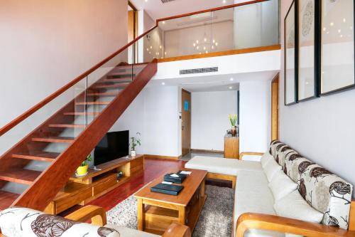 a living room with a couch and a staircase at Floral Hotel · Yingxi Riverside Deqing in Deqing