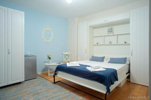 a bedroom with a large bed with blue walls at Republicii Residence in Braşov