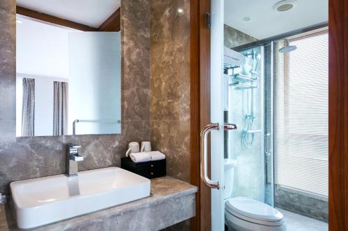 a bathroom with a sink and a toilet at Floral Hotel · Yingxi Riverside Deqing in Deqing
