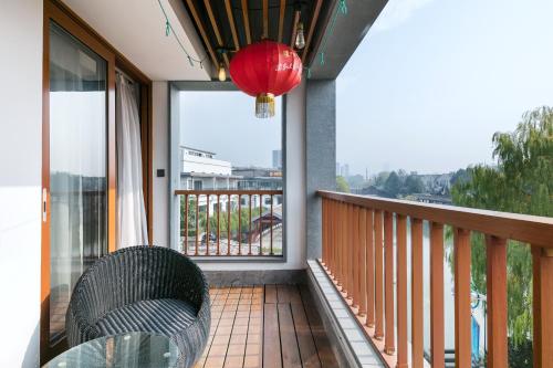 a balcony with a glass table and a lantern at Floral Hotel · Yingxi Riverside Deqing in Deqing