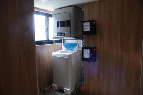 a kitchen with a microwave on top of a washer at Chillax Inn 知樂愛河館 in Kaohsiung