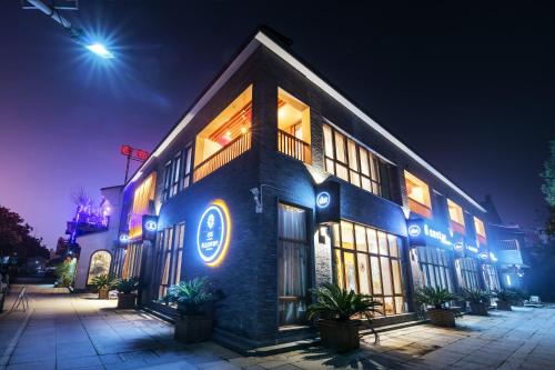 a building with blue lights on it at night at Floral Hotel · Yingxi Riverside Deqing in Deqing
