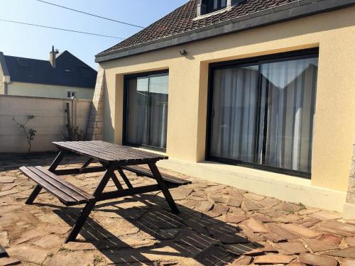 a picnic table in front of a house at Asteria in Ouistreham