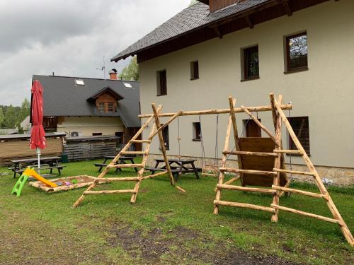 a group of wooden play equipment in a yard at Penzion Sunski in Harrachov