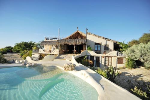 una piscina frente a una casa con un tobogán de agua en Bakuba Lodge - Le petit hôtel du Voyageur en Ankilibe