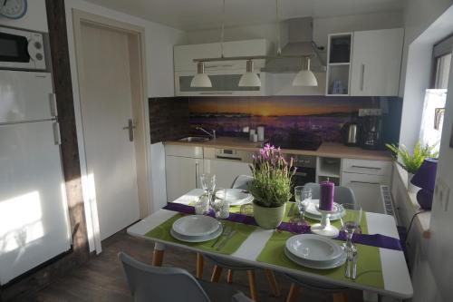 a kitchen with a table with chairs and a dining room at FerienhausTeube in Kurort Gohrisch