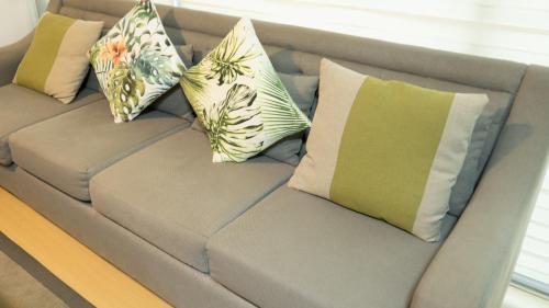 a couch with four pillows on it at Avant Serviced Suites - Personal Concierge in Manila