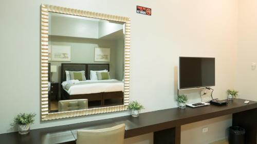 a bedroom with a bed and a large mirror at Avant Serviced Suites - Personal Concierge in Manila