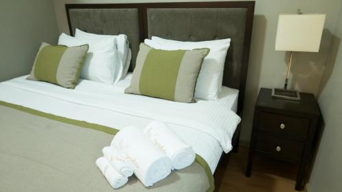 a hotel room with a bed with towels on it at Avant Serviced Suites - Personal Concierge in Manila
