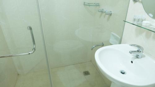 a bathroom with a shower and a toilet and a sink at Avant Serviced Suites - Personal Concierge in Manila