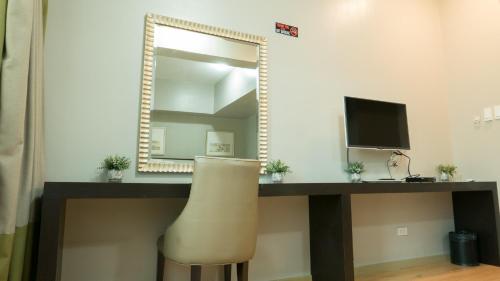 a mirror in a room with a desk and a chair at Avant Serviced Suites - Personal Concierge in Manila