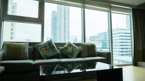 a living room with a couch and a large window at Avant Serviced Suites - Personal Concierge in Manila