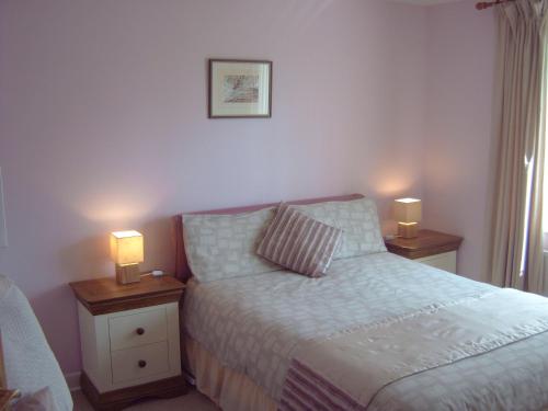 a bedroom with a bed and two lamps on tables at Ellerton B&B in Bideford