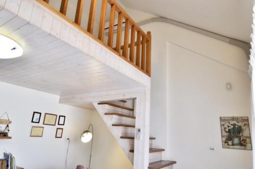 a staircase in a home with white walls and wooden ceilings at Village Villa B&B in Zhuqi