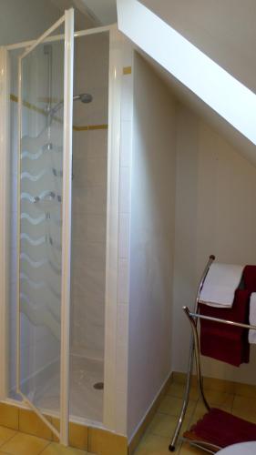 a bathroom with a glass shower in a room at Chambres d'Hôtes La Rompardais in Pléven