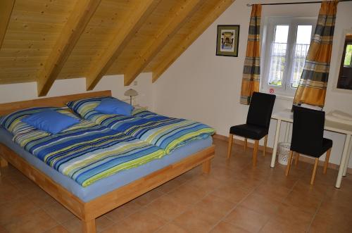 a bedroom with a bed and two chairs in it at Kellerstöckl Prantner & Haus Wohlauf in Rechnitz