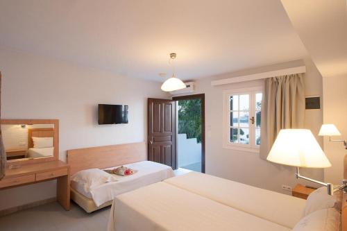 een hotelkamer met 2 bedden en een spiegel bij vassilias beach hotel in Vassilias