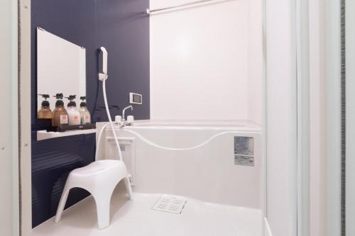 einen weißen Stuhl im Bad mit Dusche in der Unterkunft Stay SAKURA Kyoto Nijo Rikyu in Kyoto