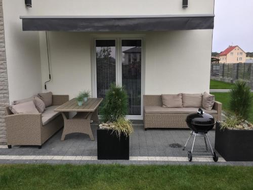 a patio with a couch and a table and a grill at Sunrise Apartaments in Rowy