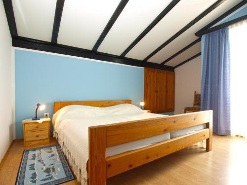 een slaapkamer met een groot bed met een houten frame bij Apartments Dragica 1251 in Fažana