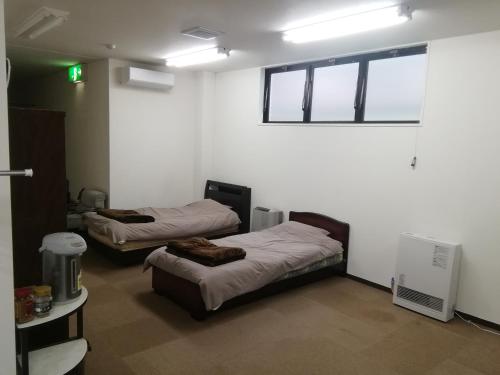 a room with two beds and a window at Seikan bildinng101 in Hakodate