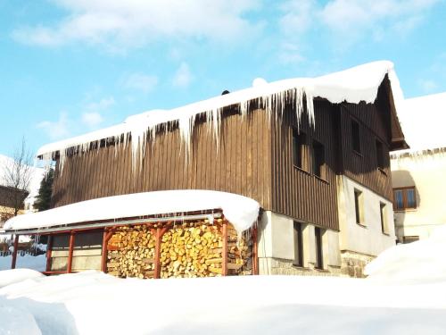 a building covered in snow with icicles on it at Chata Ondrášek in Bedřichov