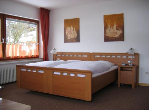 Un dormitorio con una gran cama de madera y una ventana en Gasthof Westfeld en Schmallenberg