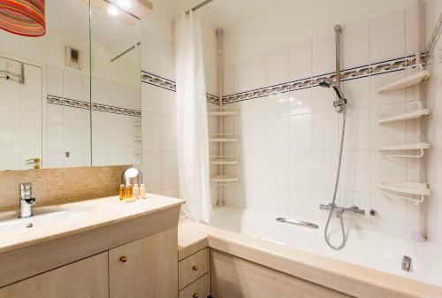 a bathroom with a tub and a sink and a shower at Veeve - Modern Brights in Paris