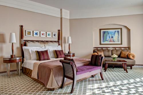 a bedroom with a large bed and a couch at Corinthia Tripoli in Tripoli