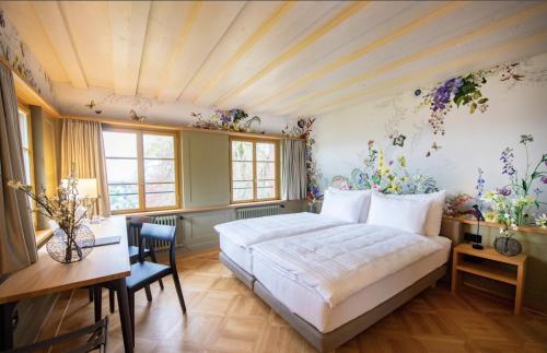 Hotel Restaurant Falkenburg في سانت غالن: غرفة نوم مع سرير كبير وورود على الجدران