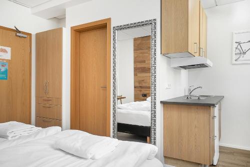 a bedroom with a mirror and a bed and a sink at Stay Apartments Einholt in Reykjavík