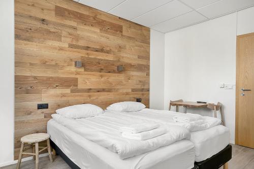 a bedroom with a large bed with a wooden wall at Stay Apartments Einholt in Reykjavík