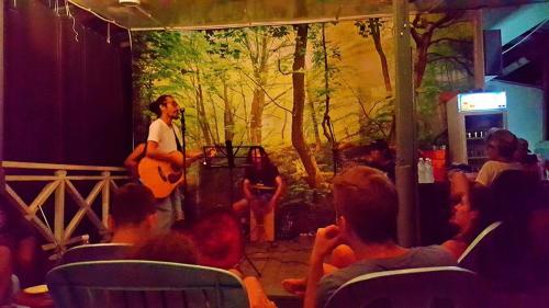 a man playing guitar in front of a crowd of people at Wild Lodge Taman Negara in Kuala Tahan