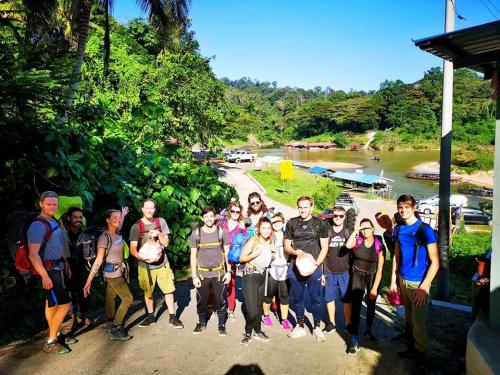 a group of people posing for a picture next to a river at Wild Lodge Taman Negara in Kuala Tahan