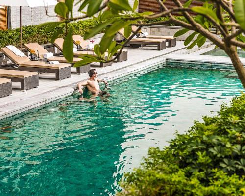 a man is in a swimming pool in a hotel at Four Seasons Hotel Shenzhen in Shenzhen