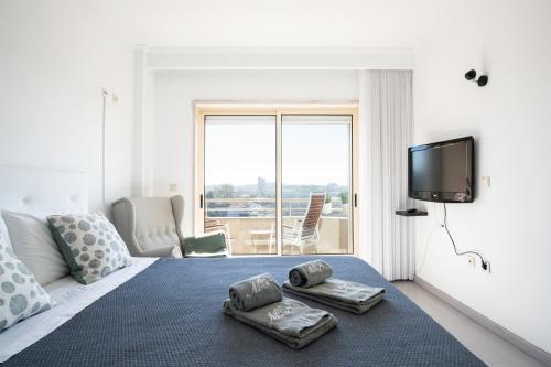 ヴィラ・ノヴァ・デ・ガイアにあるPorto Gaia River View 8 by MPのベッドルーム1室(ベッド1台、タオル2枚付)